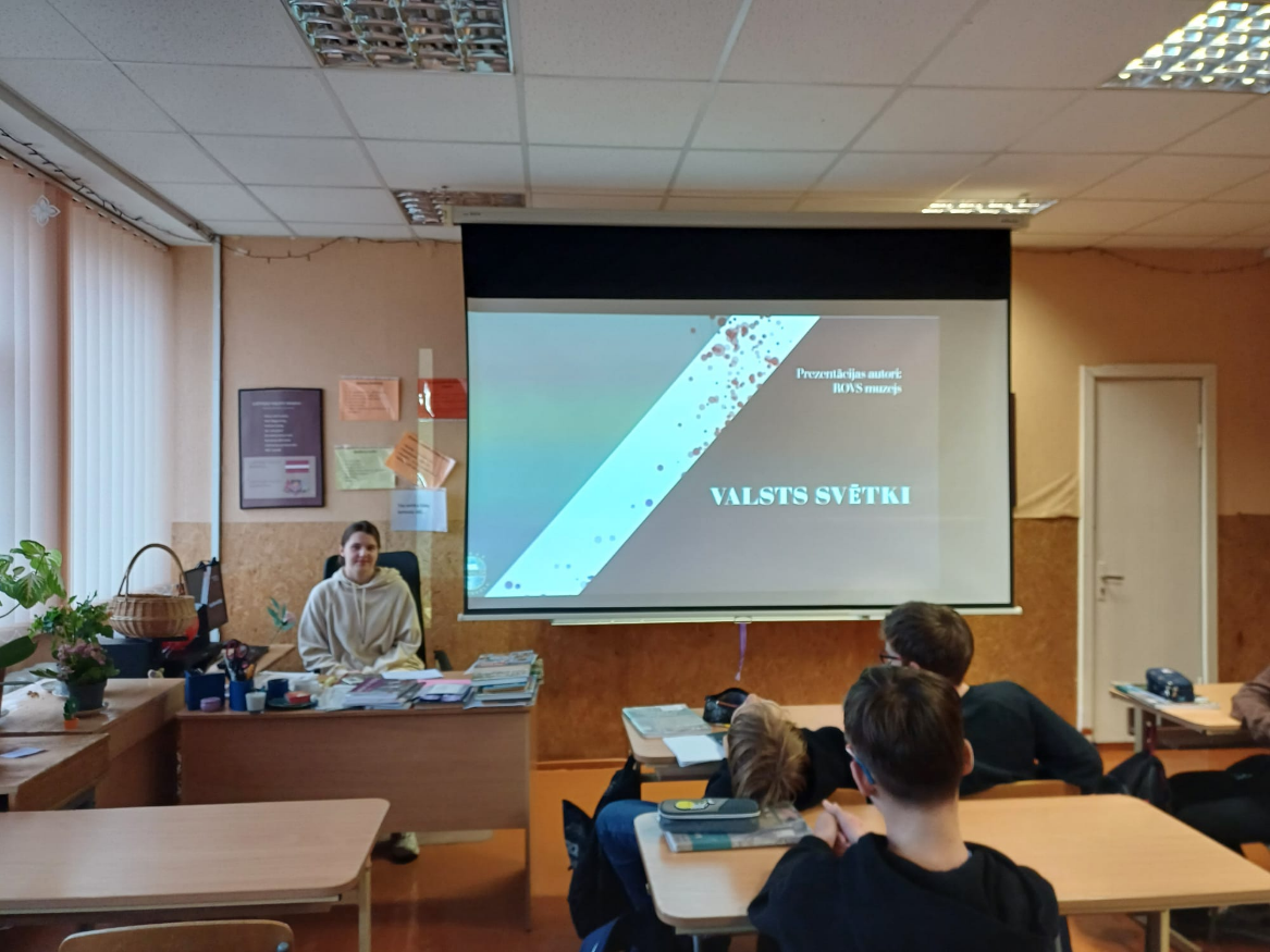ROVS  muzejā dalībniece stāsta 7.b skolniekiem par Latvijas valsts neatkarības vēsturi. 2024.gada novembris.